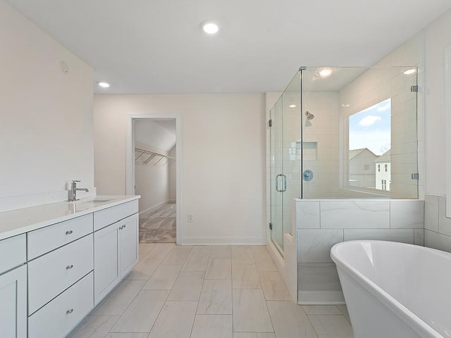 bathroom with separate shower and tub, vanity, and tile walls