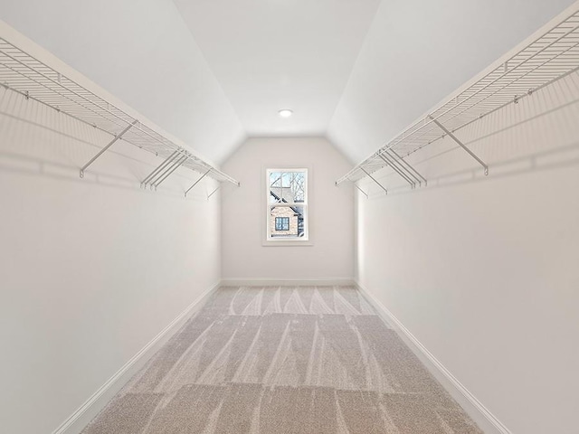 spacious closet featuring light carpet and vaulted ceiling