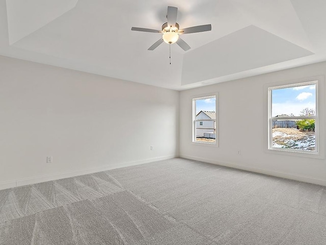 spare room with ceiling fan, carpet, and a raised ceiling