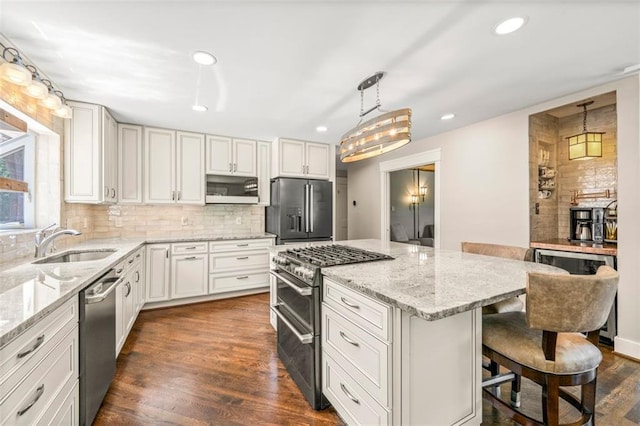 1382 Varner Rd, Marietta, GA 30062 - kitchen featuring high end appliances, a sink, a center island, backsplash, and a kitchen bar