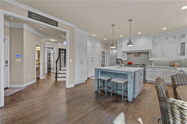 kitchen with white cabinetry, backsplash, pendant lighting, and a center island