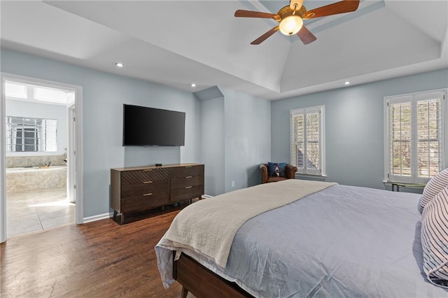 bedroom with lofted ceiling, connected bathroom, dark hardwood / wood-style floors, and ceiling fan