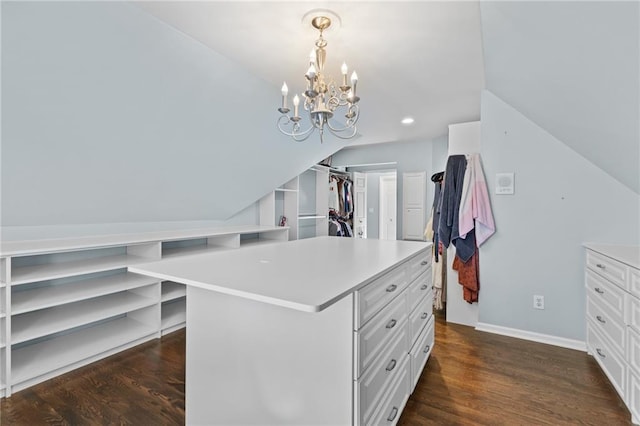 walk in closet featuring dark wood-type flooring, a chandelier, and vaulted ceiling