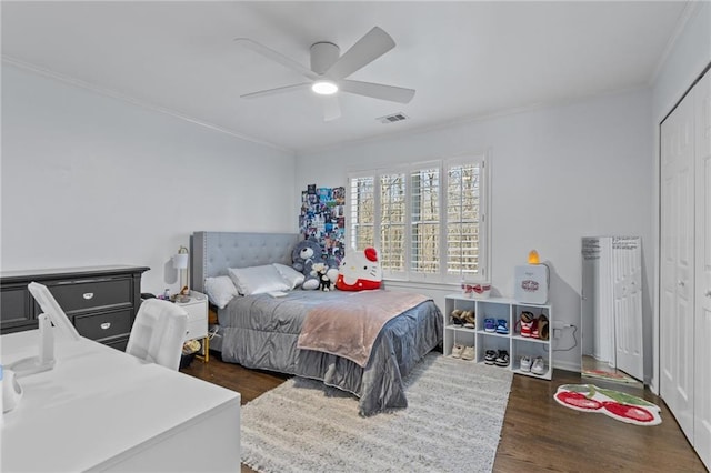 bedroom featuring ceiling fan, ornamental molding, dark hardwood / wood-style floors, and a closet