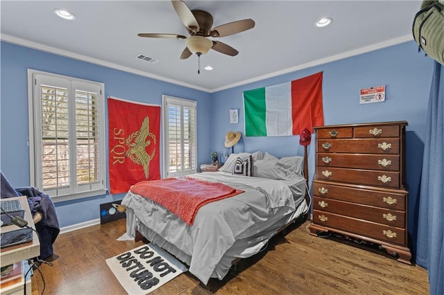 bedroom with ornamental molding, dark hardwood / wood-style floors, and ceiling fan