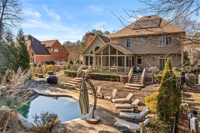 view of swimming pool featuring a patio and a sunroom