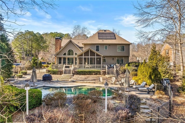 back of property featuring a patio, a sunroom, and a pool side deck