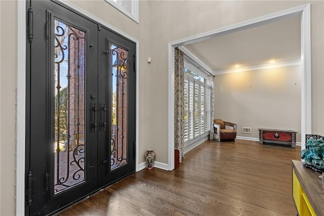 entrance foyer featuring ornamental molding, dark hardwood / wood-style floors, and french doors