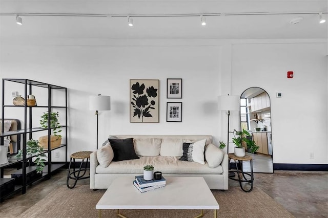 living area with track lighting and finished concrete flooring