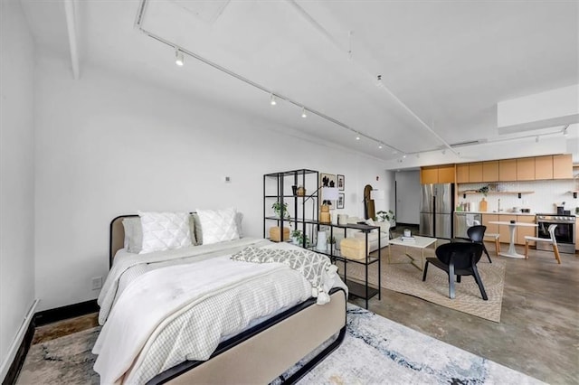 bedroom with concrete floors, freestanding refrigerator, and rail lighting