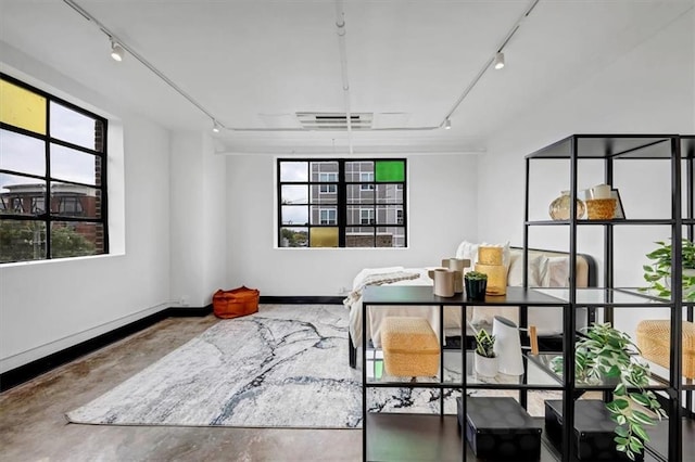 bedroom with concrete floors, multiple windows, rail lighting, and visible vents