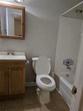 full bathroom with tile patterned floors, vanity, shower / bath combination, and toilet