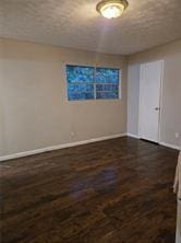 empty room with dark hardwood / wood-style floors