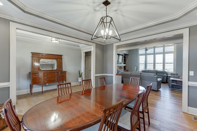 486 Gold Bullion Dr E, Dawsonville, GA 30534 - dining space featuring crown molding, a chandelier, hardwood / wood-style floors, and baseboards