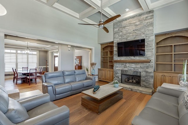 486 Gold Bullion Dr E, Dawsonville, GA 30534 - living area with a stone fireplace, coffered ceiling, a ceiling fan, wood finished floors, and a chandelier