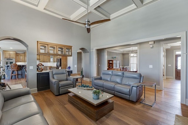 486 Gold Bullion Dr E, Dawsonville, GA 30534 - living room featuring arched walkways, coffered ceiling, ceiling fan, wood finished floors, and crown molding