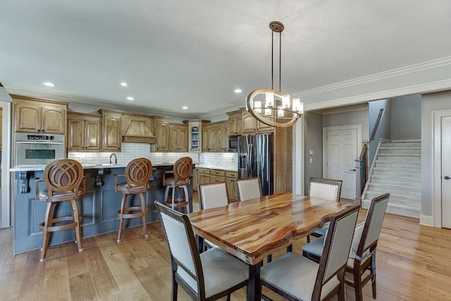 486 Gold Bullion Dr E, Dawsonville, GA 30534 - dining space featuring crown molding, light wood-style floors, a chandelier, recessed lighting, and stairway