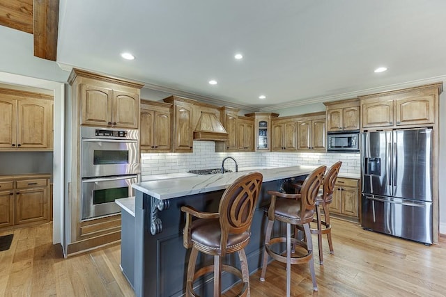 486 Gold Bullion Dr E, Dawsonville, GA 30534 - kitchen with appliances with stainless steel finishes, glass insert cabinets, decorative backsplash, light wood finished floors, and an island with sink