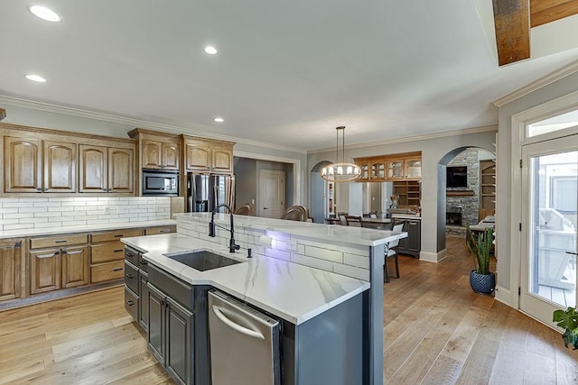 486 Gold Bullion Dr E, Dawsonville, GA 30534 - kitchen with a sink, stainless steel dishwasher, light countertops, a kitchen island with sink, and a stone fireplace