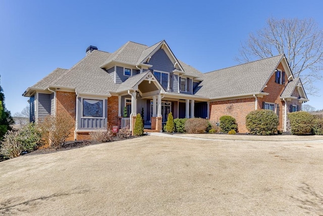 486 Gold Bullion Dr E, Dawsonville, GA 30534 - craftsman inspired home featuring brick siding, a chimney, covered porch, and roof with shingles