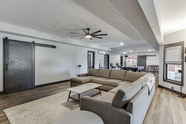 486 Gold Bullion Dr E, Dawsonville, GA 30534 - living room with a barn door, light wood finished floors, baseboards, a wall mounted air conditioner, and recessed lighting