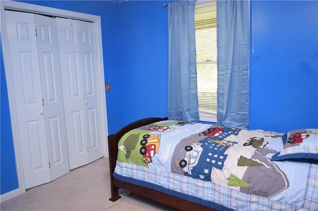 bedroom with light colored carpet and a closet