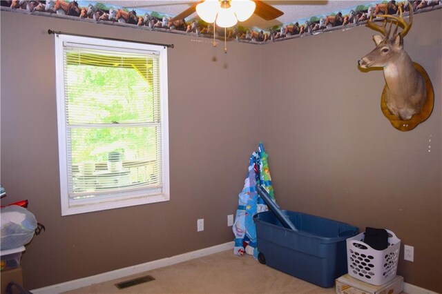 interior space featuring ceiling fan and carpet floors