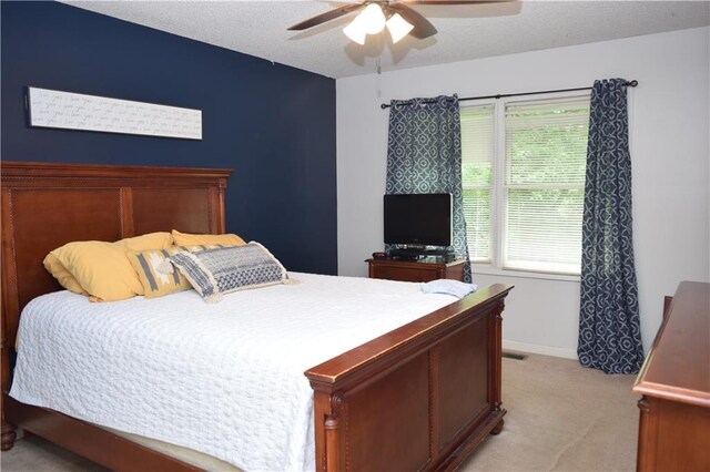 carpeted bedroom with multiple windows, ceiling fan, and a textured ceiling