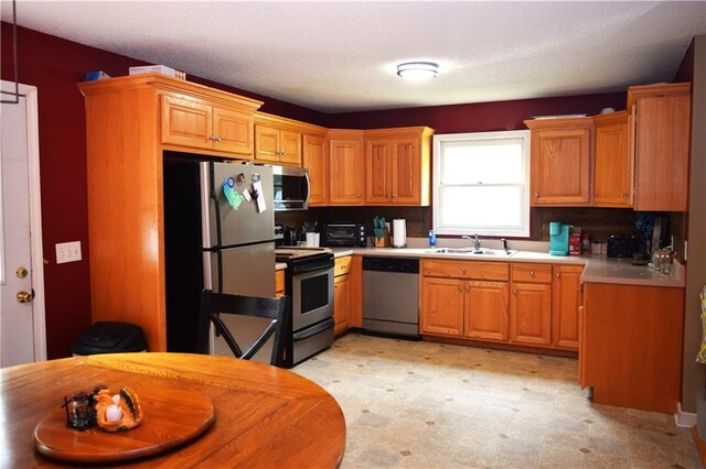 kitchen featuring a textured ceiling, sink, and stainless steel appliances