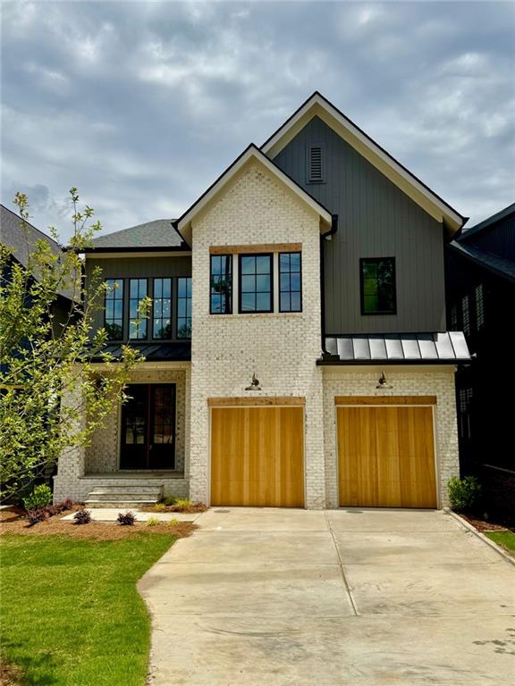 2583 Apple Valley Rd, Brookhaven, GA 30319 - view of front facade featuring concrete driveway, an attached garage, a standing seam roof, brick siding, and a front yard