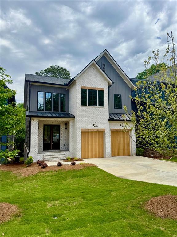 2583 Apple Valley Rd, Brookhaven, GA 30319 - modern farmhouse featuring a standing seam roof, a garage, concrete driveway, metal roof, and a front yard