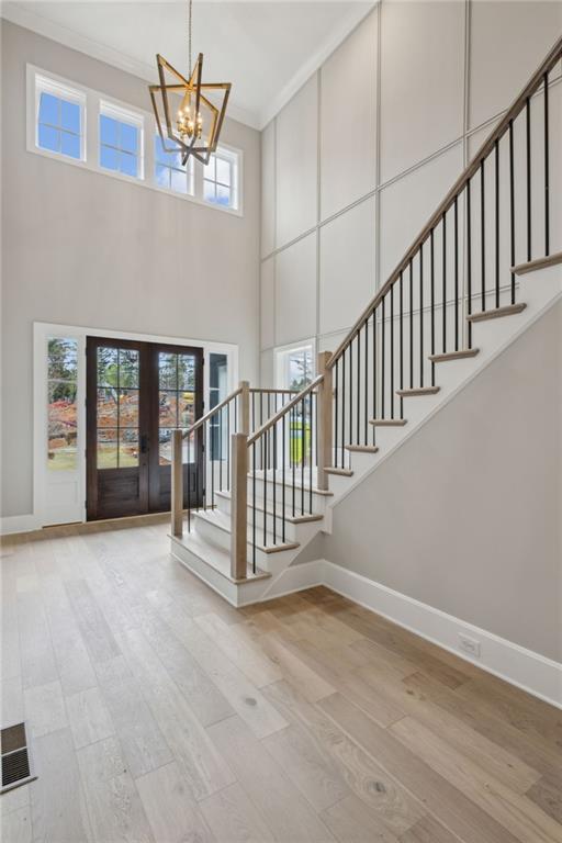 2583 Apple Valley Rd, Brookhaven, GA 30319 - entrance foyer with baseboards, a chandelier, crown molding, stairs, and wood finished floors