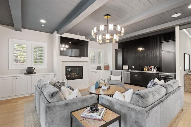 2583 Apple Valley Rd, Brookhaven, GA 30319 - living area with beamed ceiling, light wood-style flooring, a chandelier, wine cooler, and a glass covered fireplace