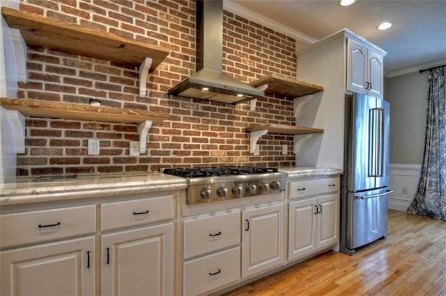 kitchen featuring open shelves, light wood-style floors, ornamental molding, appliances with stainless steel finishes, and wall chimney exhaust hood