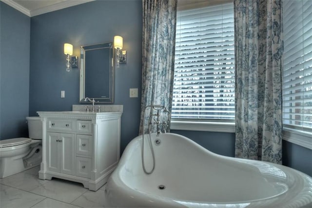 full bathroom featuring toilet, vanity, a freestanding bath, marble finish floor, and ornamental molding