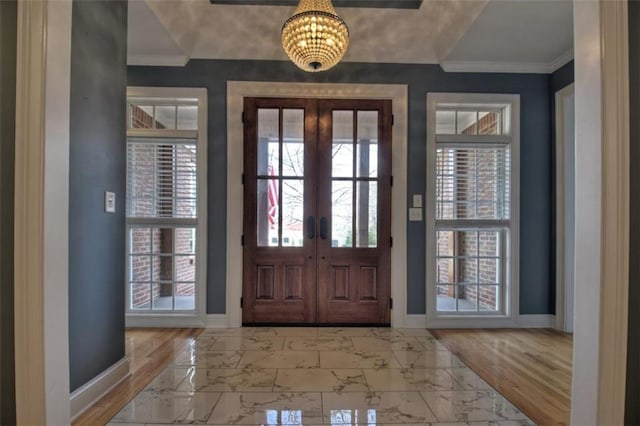 entrance foyer featuring marble finish floor, baseboards, french doors, and ornamental molding