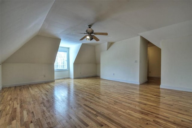 additional living space with lofted ceiling, ceiling fan, baseboards, and wood finished floors