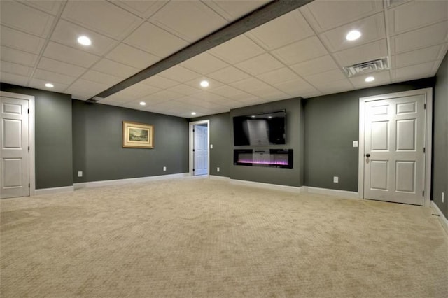 finished basement featuring a glass covered fireplace, visible vents, and carpet flooring