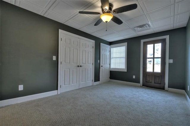 unfurnished bedroom featuring light carpet, visible vents, baseboards, ceiling fan, and a closet