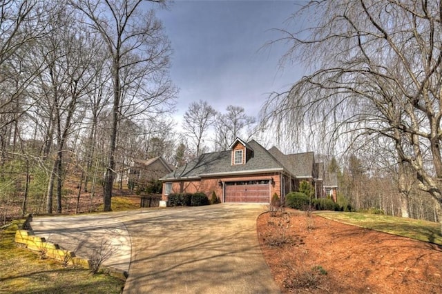 exterior space with driveway, an attached garage, and brick siding