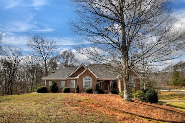 view of front of property featuring brick siding and a front yard