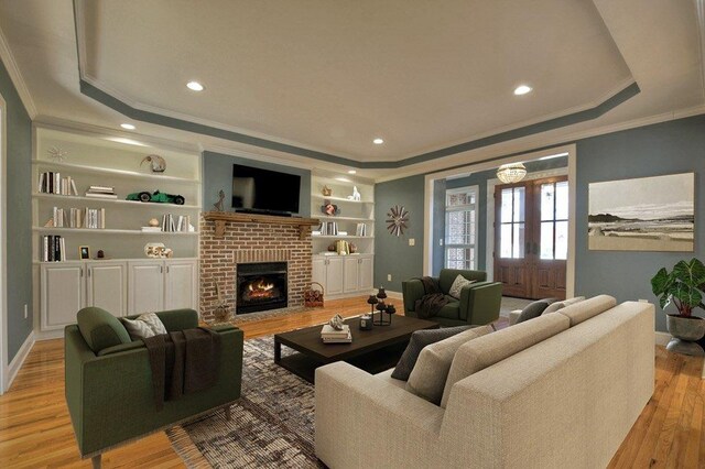 living area featuring a tray ceiling, french doors, a brick fireplace, wood finished floors, and baseboards