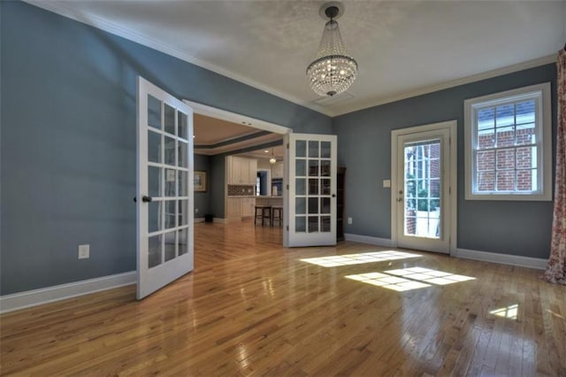 doorway featuring ornamental molding, french doors, wood-type flooring, and baseboards