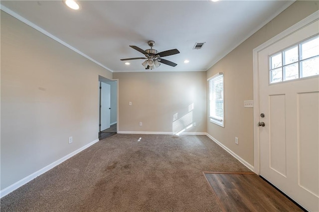 carpeted entrance foyer featuring ornamental molding and ceiling fan