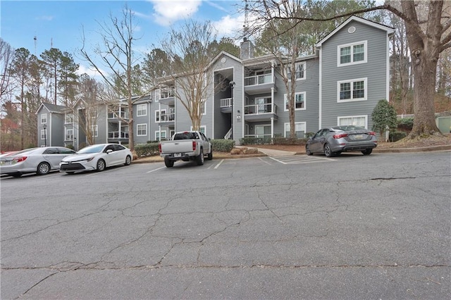 view of property with uncovered parking and a residential view