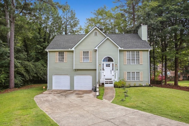 bi-level home featuring a garage and a front lawn