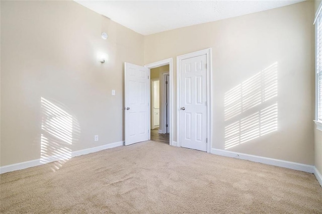 spare room featuring vaulted ceiling and light carpet