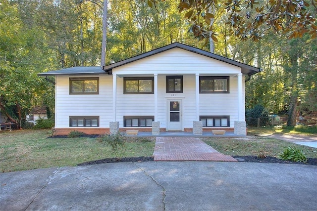 split foyer home featuring covered porch and a front yard