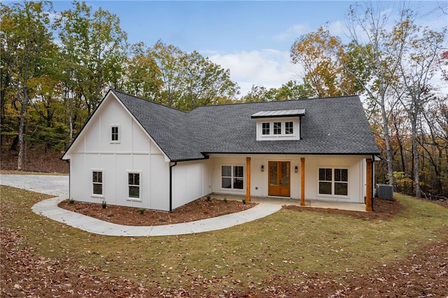 modern farmhouse style home with cooling unit, a patio, and a front lawn