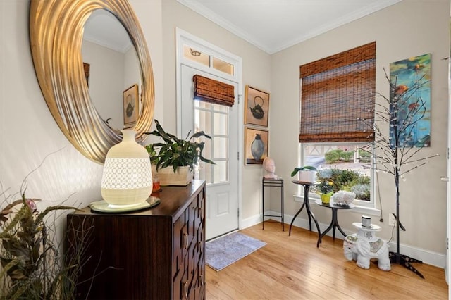 entrance foyer with ornamental molding, light wood finished floors, and baseboards